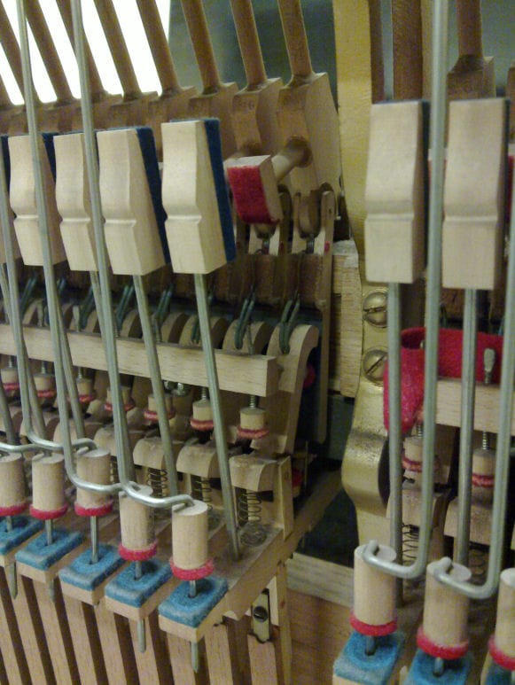 Pianon koneisto. Lähikuvassa koneiston osia, kuten koppari, kannus ja pääjäsen