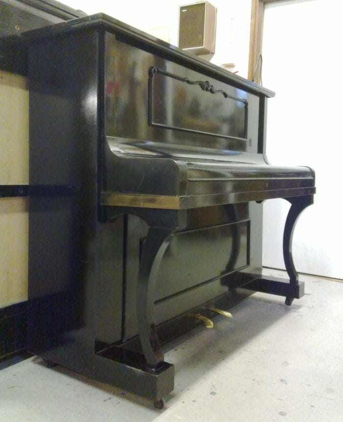 Vanha entisöity piano, jonka pinnat on uudelleen puleerattu